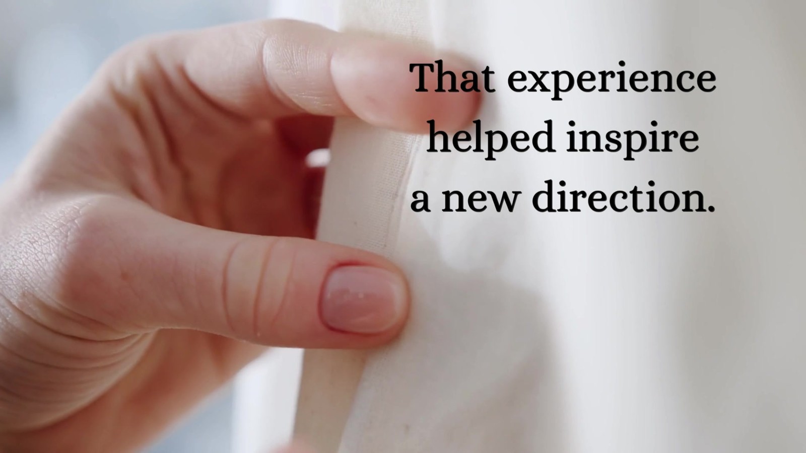A close view of a hand working with ivory fabric, from our Vera Wang reel
